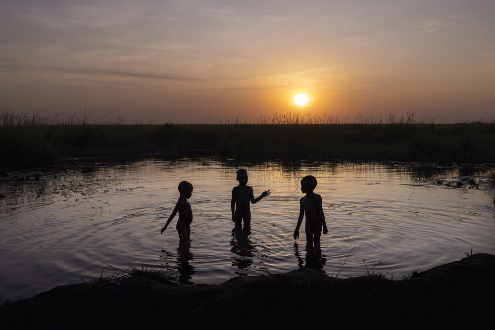 Children play in the Sudd swamp next to the flooded village of Mayendit, Unity State, South Sudan on November 22, 2022. The Sudd is vast marshland in South Sudan, Africa's largest wetland and one of the largest tropical wetlands in the world which approximately 1 million people inhabiting it. Since 2019, South Sudan has suffered from unprecedented floods which have submerged large swathes of the country, and entire villages and displaced hundreds of thousands of people. Multi-year inundations like this haven’t happened in South Sudan in more than six decades. Now, the water is no longer draining away leaving more than 8 million people at risk of starvation.Mayendit is one of those villages which became an island surrounded by flood waters. The floods have caused extensive infrastructural damage to roads, bridges, schools, sanitation, and hygiene facilities limiting access to health and education infrastructures, and disrupting markets and livelihoods. Two-thirds of the population has fled to more stable and dry ground, becoming IDPs, while the host the community remained is struggling to survive.