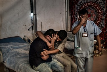 Inside the hospital on the way to Sirte, a friend is consoling a relative who mourns the death of a fighter loyal to Libya's Government of National Accord. The fighter has been killed by IS (Islamic State) militants on October 2, 2016.