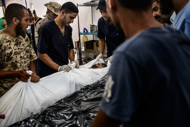 Doctors and fighters of the Libyan Government of National Accord move the corpse of a fellow fighter killed during battle against the Islamic State (IS) in Sirte on September 22, 2016.